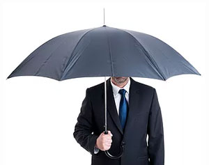 man in suit under umbrella 