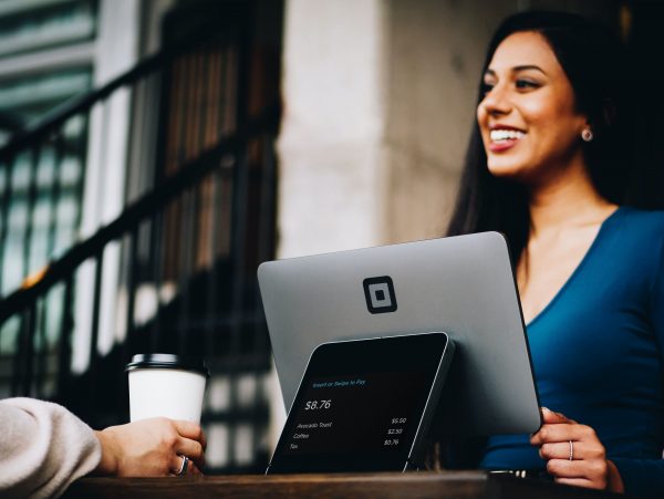 Smiling cashier with square card reader