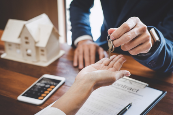 man handing placing keys into a woman's hand