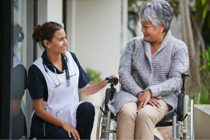 Lady in a wheelchair talking to a nurse